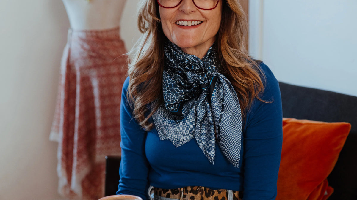 Melanie Laslett wearing the Camo Indigo Classic Square silk scarf in her design studio.