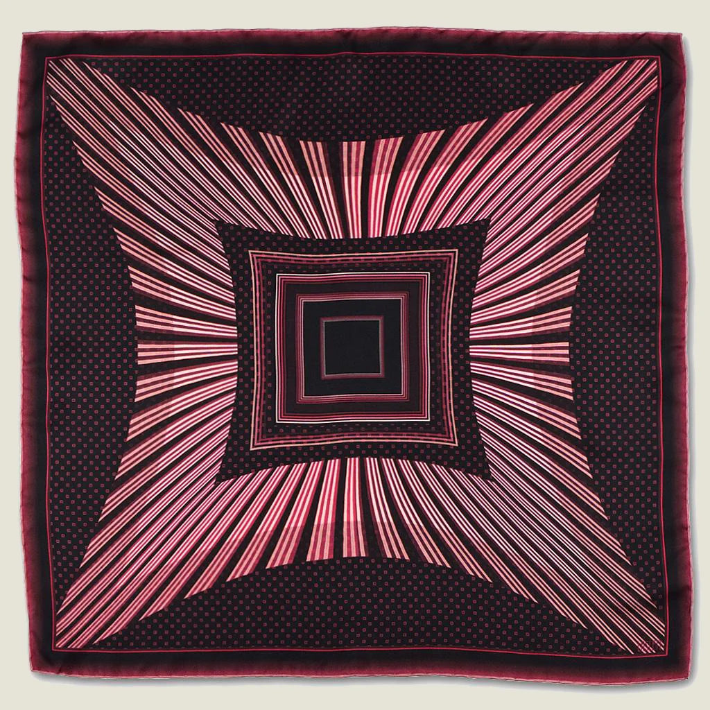 Houston Ruby Silk Bandana from Laslett England pictured in flat lay with a graphic radial stripe in ruby and rose pink.