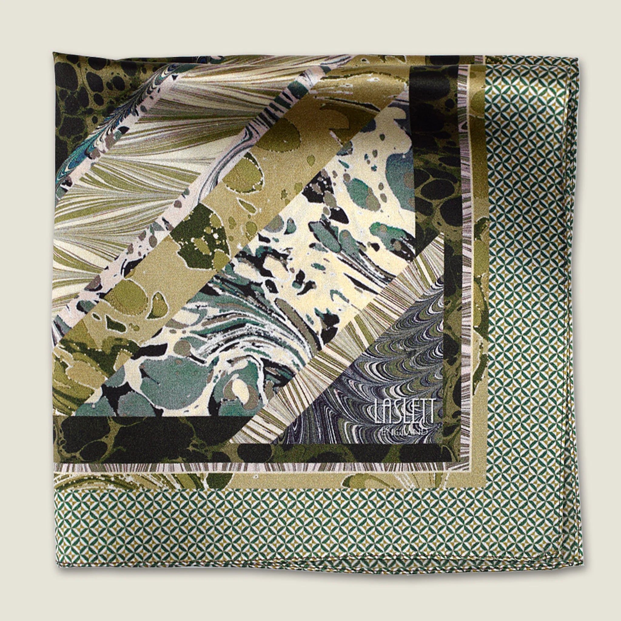 This Marble Camo pocket square applies the flowing, layered quality of traditional hand-marbling to a palette of olive green, teal, black and ivory. Photographed folded into four with the Laslett logo visible.