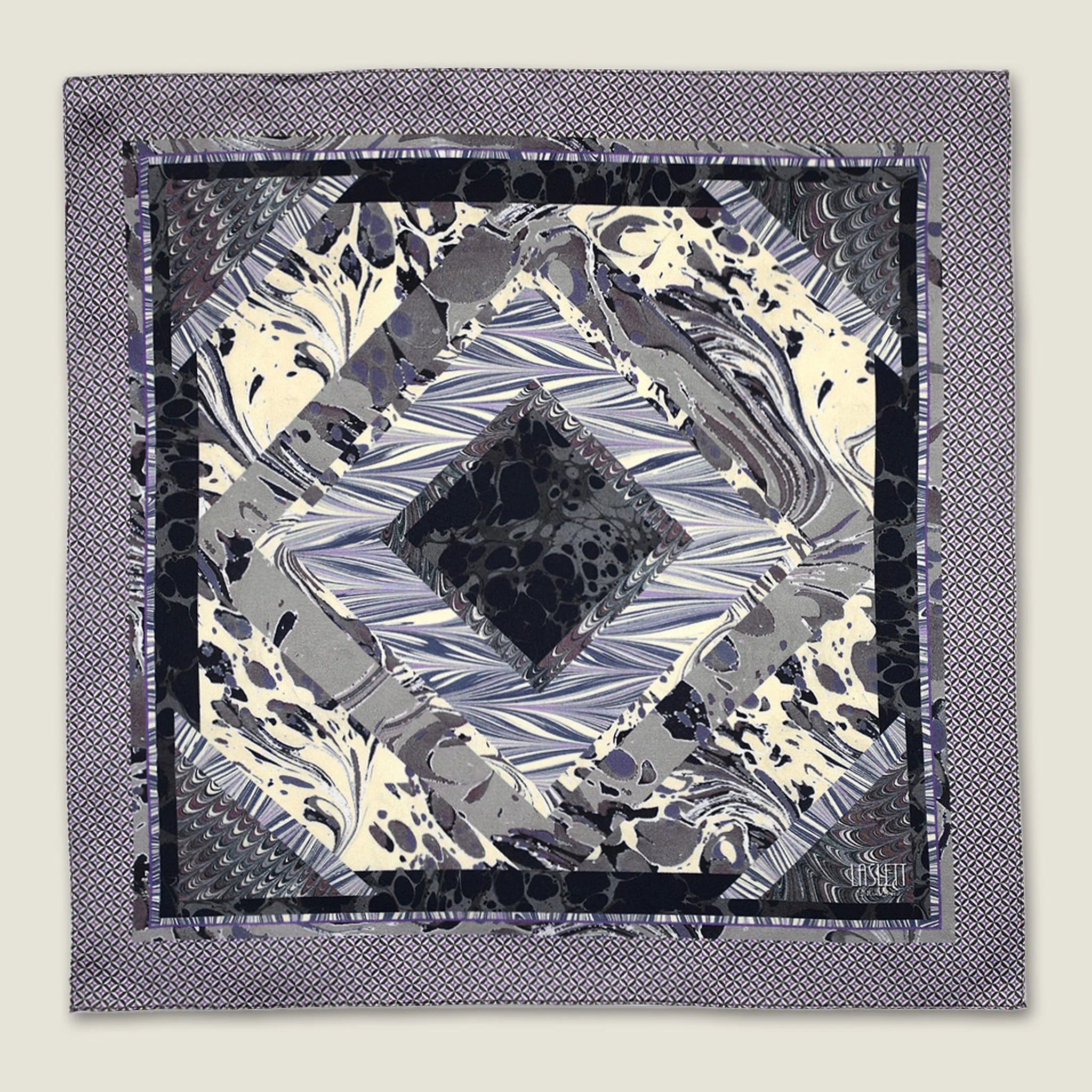 The 100% silk Marble Slate Pocket Square centre field carries multiple marble techniques including feathered combing, stone drop patterns and swirled forms in slate grey, charcoal and dusted lilac, with a geometric tiled border. Photographed in flat lay.