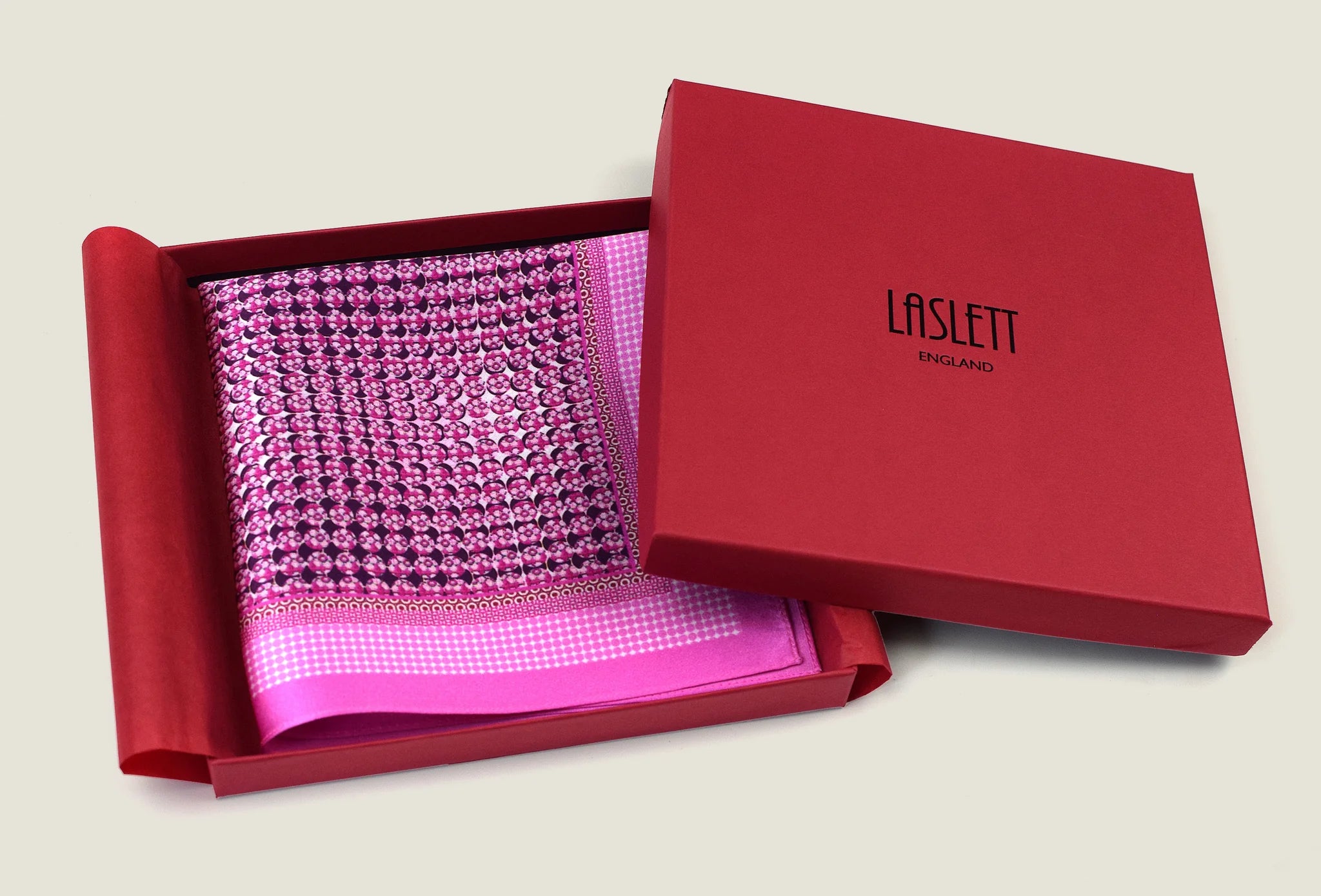 This Matrix Pink pocket square has a striking geometric design that reveals, on closer inspection, repeating graphic lines and patterns. In soft dusty pink with charcoal and white, square is shown in the signature red gift box.
