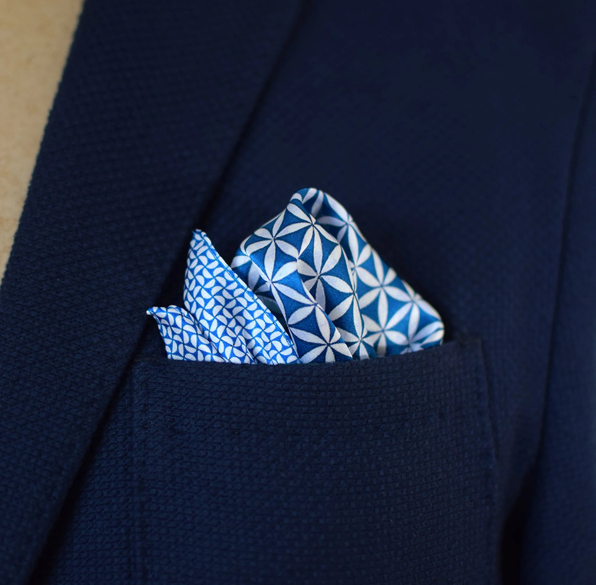 100% silk Moresque Blue Pocket Square in blue by Laslett England. Square is shown arranged in a blue suit pocket to show the central pattern and the smaller geometric pattern of the silk.