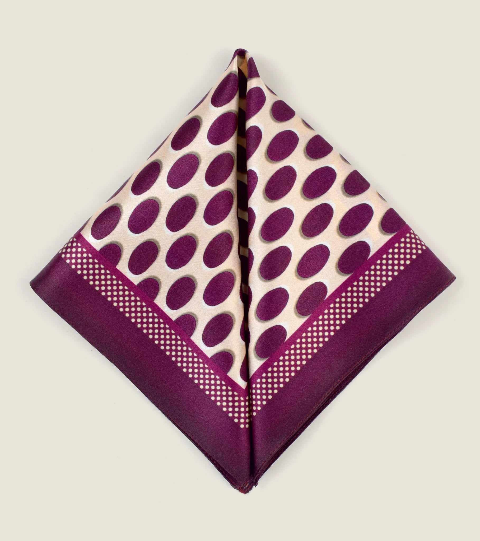 Oval Spot Burgundy pocket square from Laslett England folded into two triangles to show the modern retro pattern.