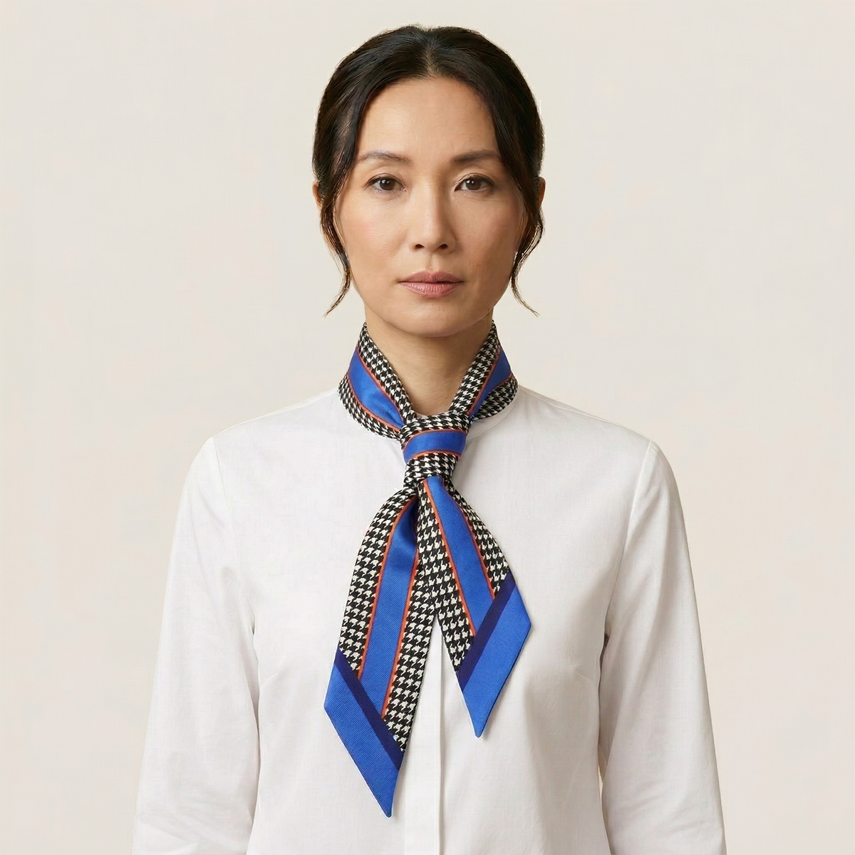 100% silk Dogtooth Blue Laslett Ribbon in black and blue by Laslett England. Model is photographed with the ribbon tied around her neck.