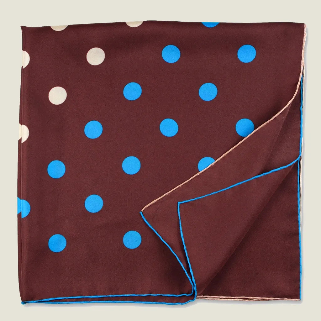 Laslett England Solitaire Chestnut Foulard displayed folded into four with folded edges. Scarf is in chestnut silk satin with cornflower blue and cream polka dots.