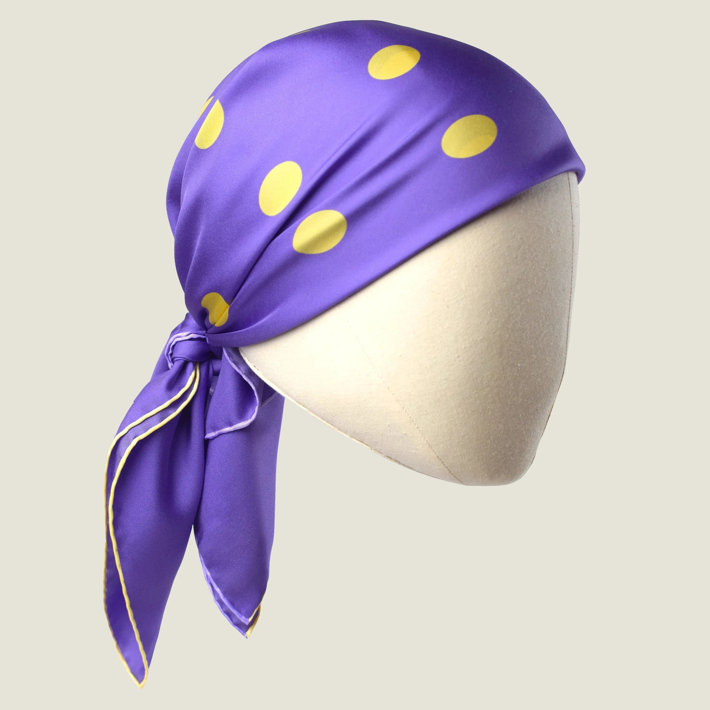 Laslett England Solitaire Violet Foulard knotted as a head covering, violet silk satin with lemon polka dots.