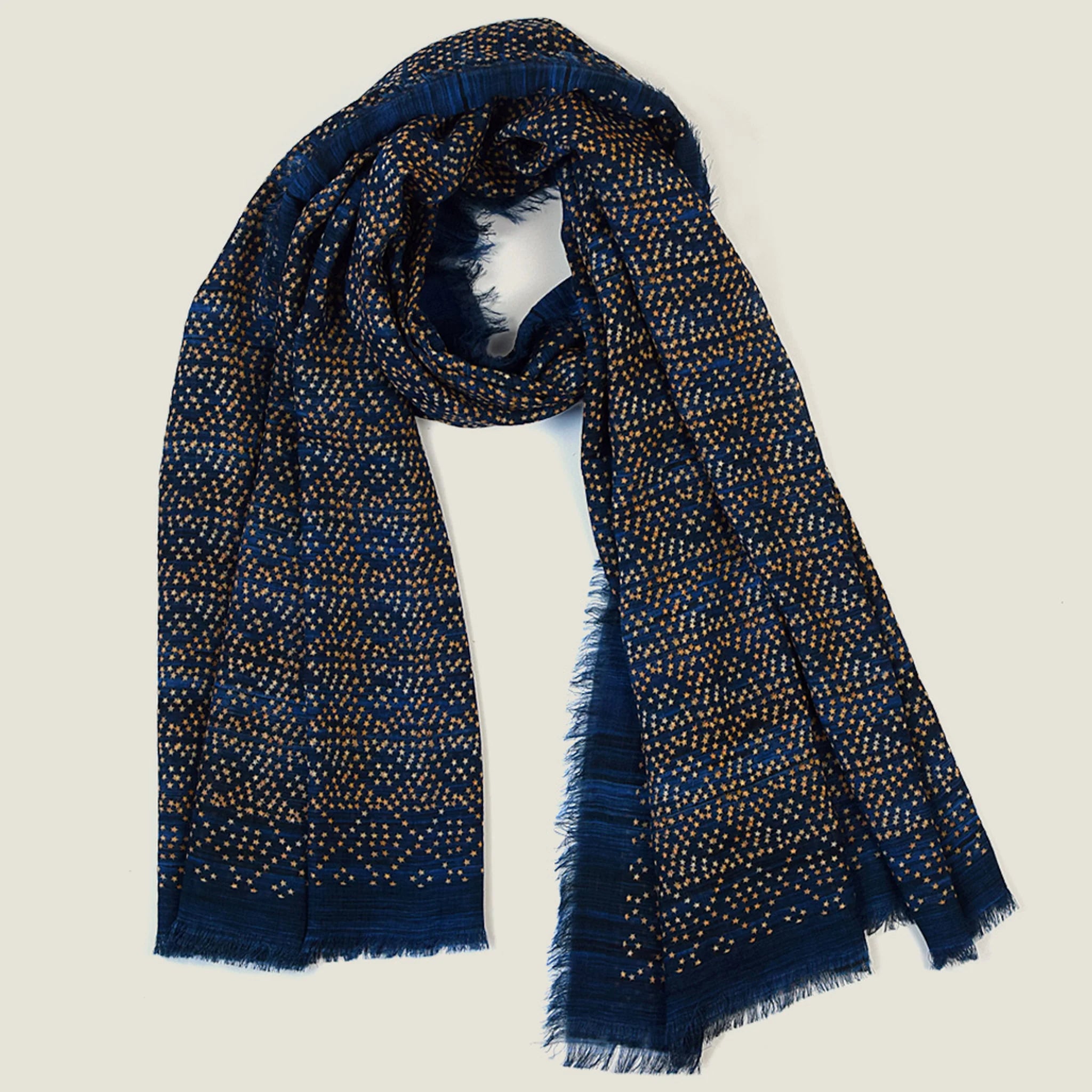 Laslett England Starry Indigo Laslett Wrap flat lay hanging open, showing deep indigo ground with bronze and gold micro-star print and hand-fringed hem