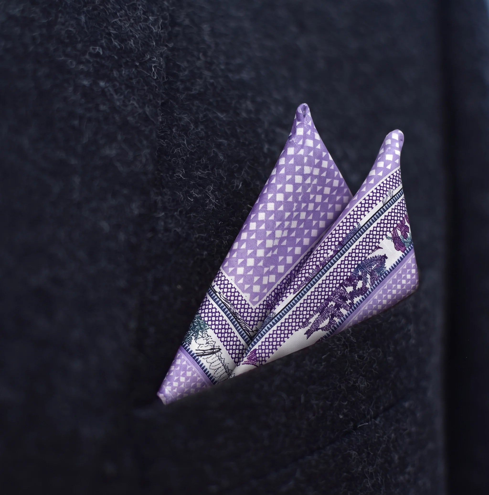 Laslett England Panama Lilac pocket square pictured folded into a triangle in a ark suit jacket.