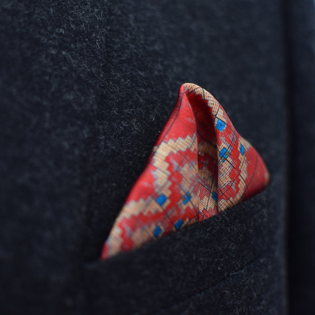 Laslett England Aztec Red pocket square worn in navy suit breast pocket, red geometric print with multiple pocket points