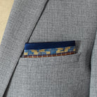 100% silk Aztec Blue Pocket Square in blue by Laslett England. Pocket square is shown neatly arranged in a grey suit jacket pocket. 
