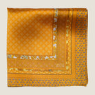 Batik Patchwork Gold pocket square in gold with an intricate patchwork of geometric patterns. Scarf is shown folded in four in flat lay. 