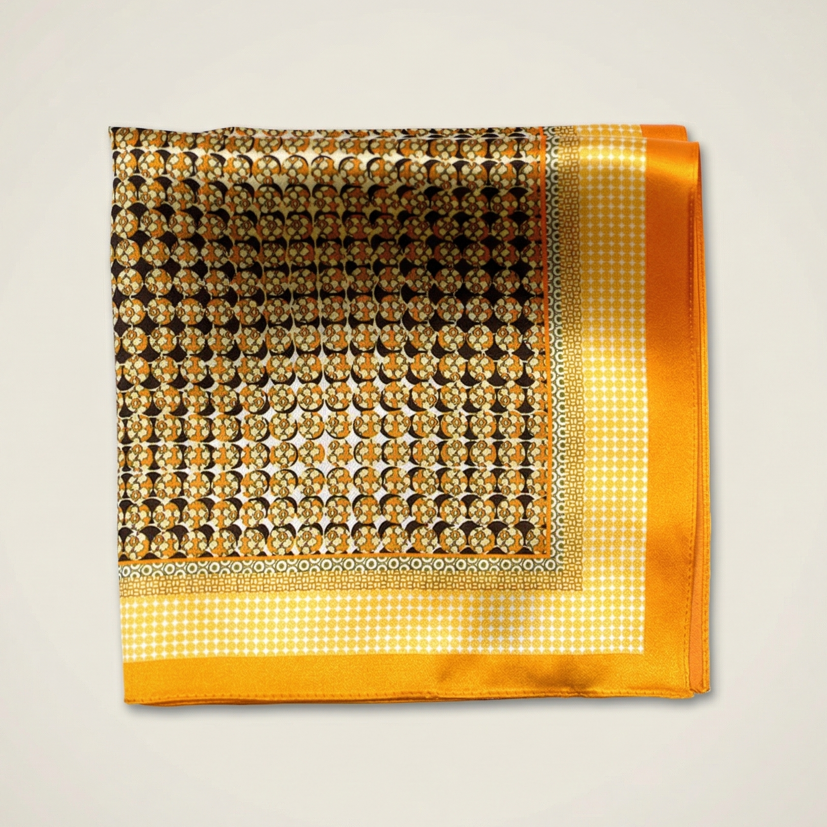 100% silk Matrix Gold Pocket Square has a futuristic geometric design that reveals, on closer inspection, repeating graphic lines and patterns across the surface. Square is shown folded into four on a neutral background. 