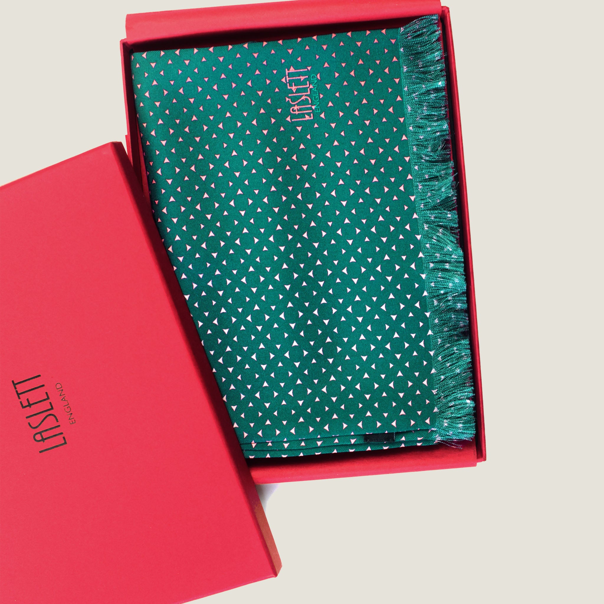 Laslett England Revival Teal Silk Oblong folded in gift box, showing blush pink triangle dot print on deep teal green 100% silk twill with pin-fringed hem