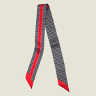 100% silk Dogtooth Red Laslett Ribbon in black and red by Laslett England. Ribbon is shown in flat lay with the Laslett logo and contrasting pattern on each side. 