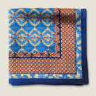 100% silk Aztec Blue Pocket Square in blue by Laslett England. The square is shown folded into 4 to show the Laslett England signature and the Aztec and geometric patterns. 