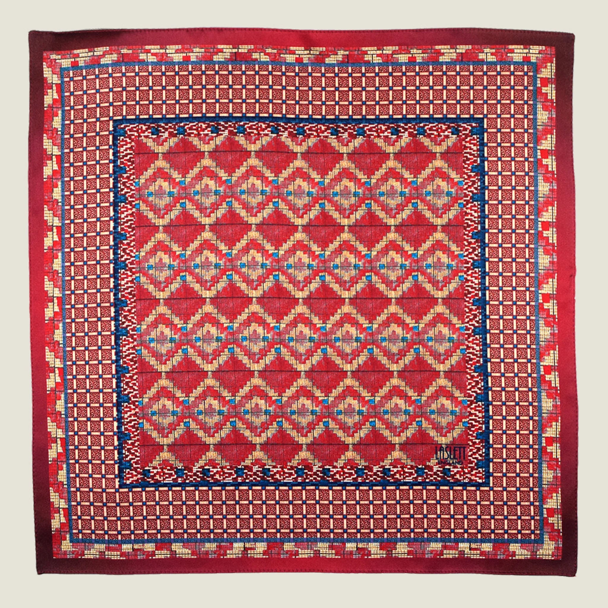 Laslett England Aztec Red pocket square flat lay, red ground with geometric Aztec repeat and navy border detail.