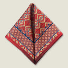 Laslett England Aztec Red silk pocket square folded to diamond point, red and navy geometric Aztec print