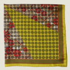 Laslett England Cadiz Silk Bandana folded flat showing mustard gold spot section of radiating geometric print on silk twill.