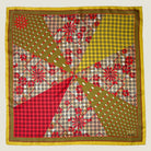 Laslett England Cadiz Silk Bandana flat lay showing all eight radiating sections with stylised florals, spots and geometric patterns in camel, olive, red and mustard gold.