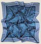 Laslett England Camo Indigo Classic Square knotted as neckerchief, navy and indigo print on cream background. Shown in flat lay. 