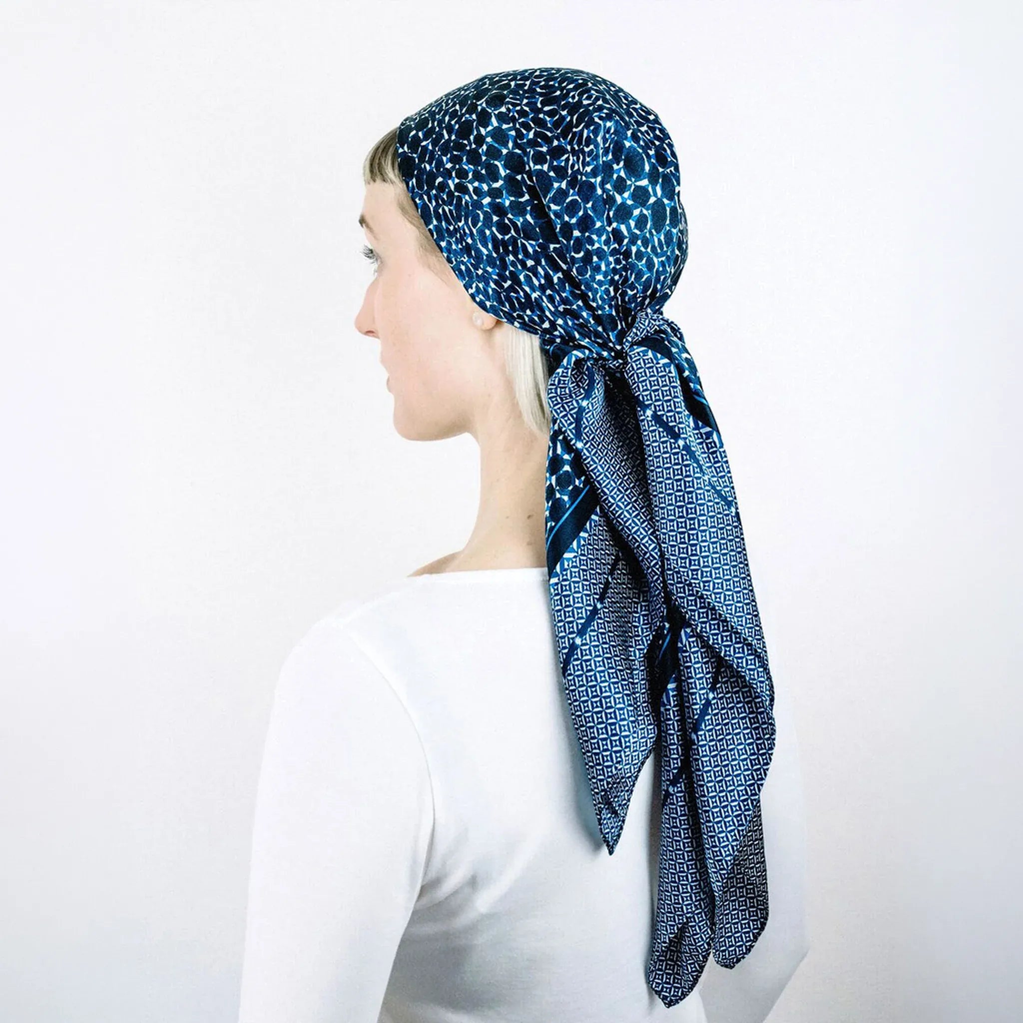Model is turned away from the camera wearing the Laslett England Camo Indigo Classic Square tied around her head. 