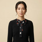 100% silk Coco Silk Bow in black and red by Laslett England. Photographed worn at the neck on a model. 