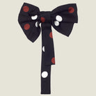 100% silk Coco Silk Bow in black with red and white dots. Photographed against a neutral background. 