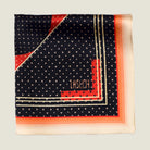 Laslett England Deco Noir pocket square corner detail, red and gold geometric border on black silk with triangle dot ground.