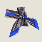 100% silk Dogtooth Blue Laslett Ribbon in black and blue by Laslett England. Ribbon is shown tied into a bow and displayed against a neutral background. 