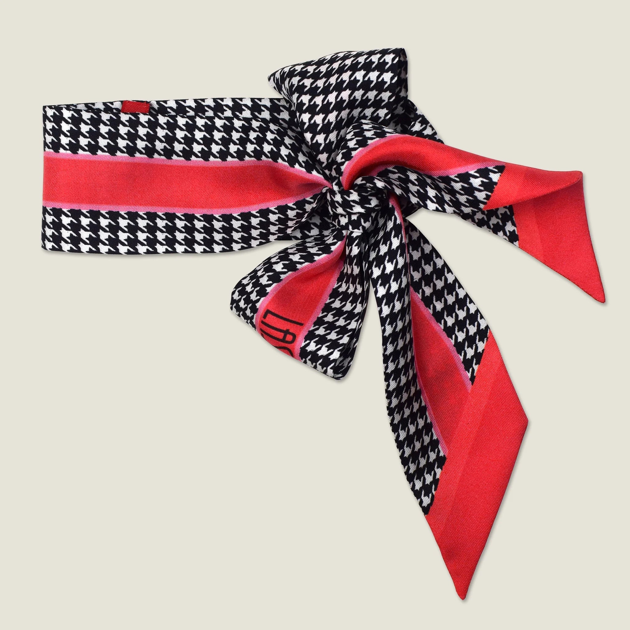 100% silk Dogtooth Red Laslett Ribbon in black and red by Laslett England. The ribbon is pictured tied into a bow. 