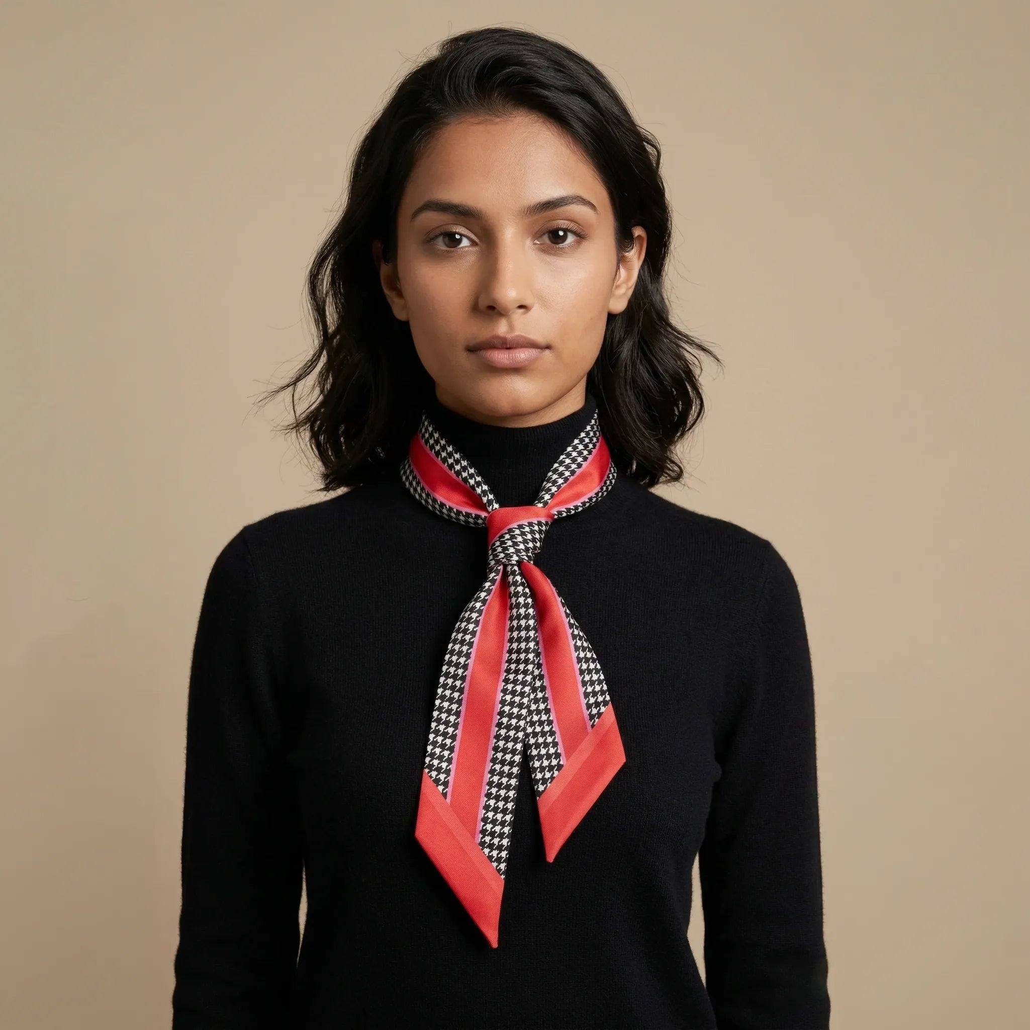 100% silk Dogtooth Red Laslett Ribbon in black and red by Laslett England. Knotted around the model's neck so that it drapes over the chest. 