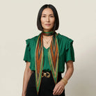 100% silk Riviera Emerald Laslett Diamond in orange; green; geometric by Laslett England. Tied once at the neck and then falling in a relaxed drape. 