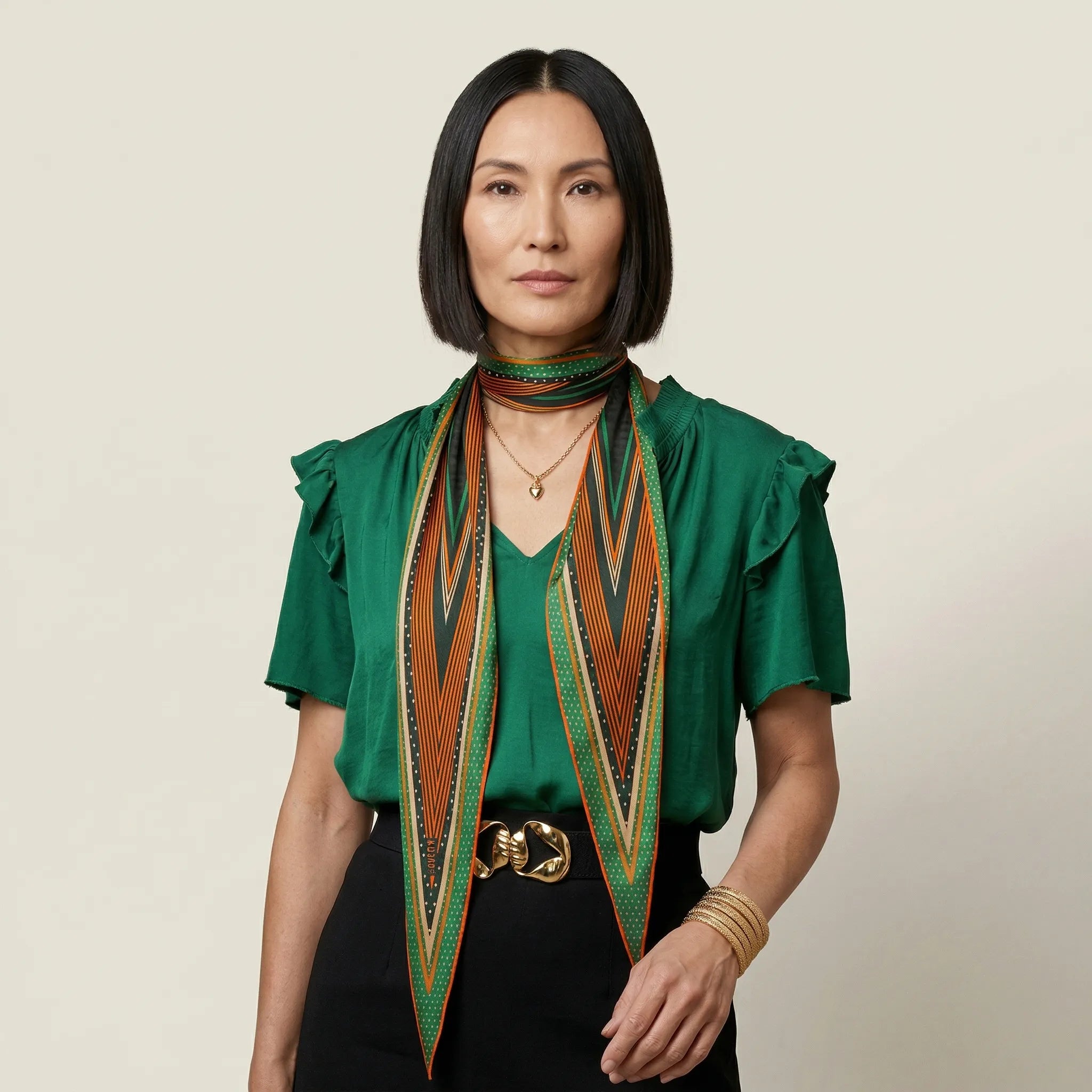 100% silk Riviera Emerald Laslett Diamond in orange; green; geometric by Laslett England. Tied once at the neck and then falling in a relaxed drape. 