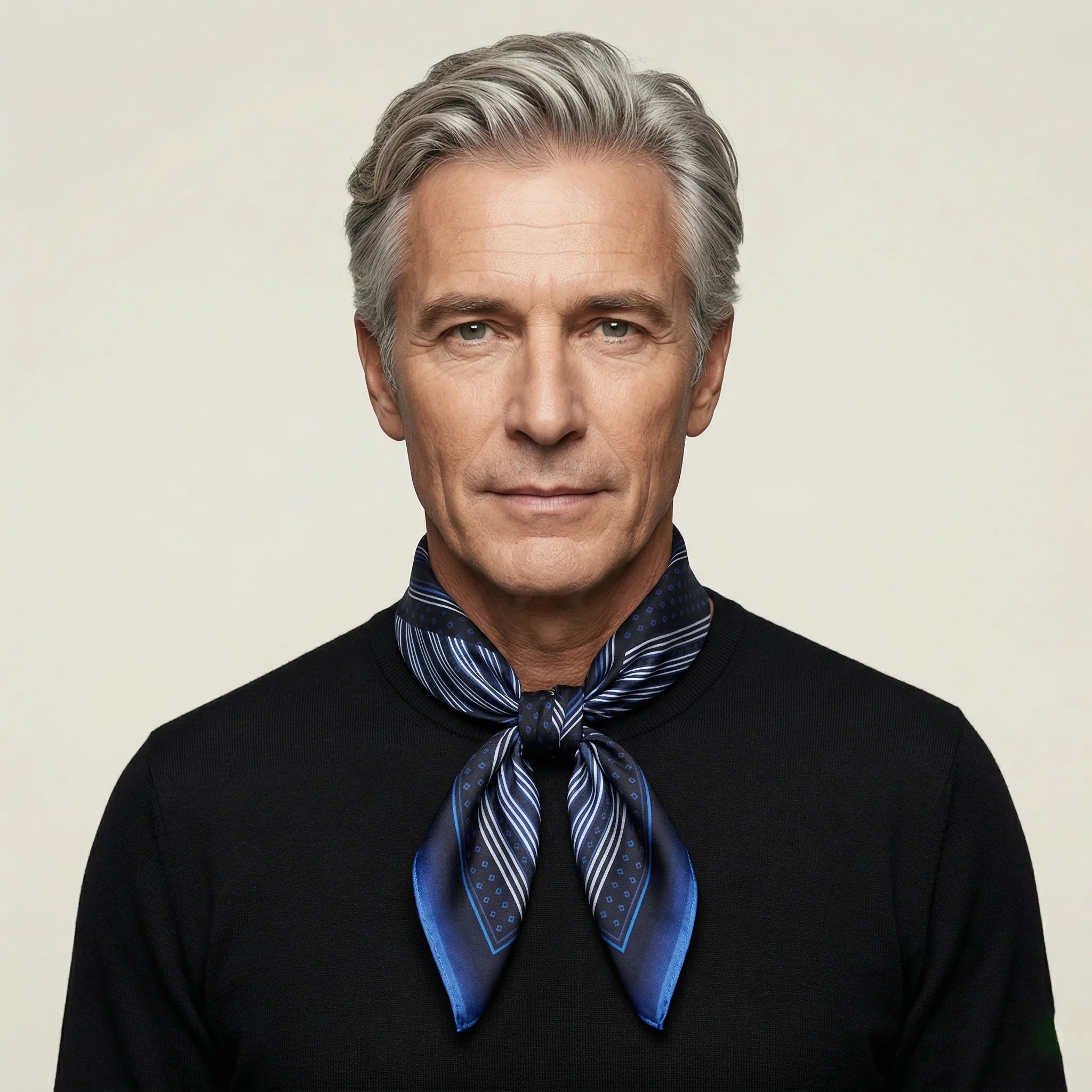 Laslett England Houston Midnight Silk Bandana worn knotted at neck by male model in black jacket, showing midnight blue radial stripe print.