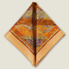 100% silk Marble Amber pocket square is inspired by the decorative marbled papers found inside antique and fine books. Shown folded into a double triangle against a neutral background. 