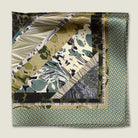 This Marble Camo pocket square applies the flowing, layered quality of traditional hand-marbling to a palette of olive green, teal, black and ivory. Photographed folded into four with the Laslett logo visible. 