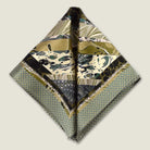 This Marble Camo pocket square applies the flowing, layered quality of traditional hand-marbling to a palette of olive green, teal, black and ivory. Photographed folded into two triangles. 