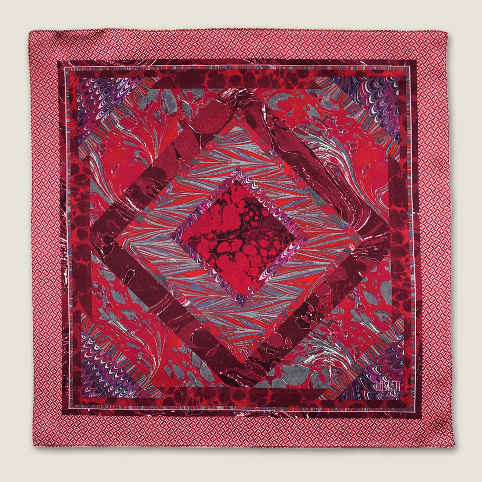 100% silk Marble Red pocket square print carries the flowing, layered quality of traditional hand-marbling in deep red and cream tones with a geometric border. Photographed in flat lay. 
