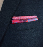 100% silk Marble Red pocket square print carries the flowing, layered quality of traditional hand-marbling in deep red and cream tones with a geometric border. Photographed folded into a square to show both the marbled centre and the geometric border.