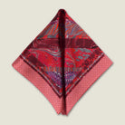 100% silk Marble Red pocket square print carries the flowing, layered quality of traditional hand-marbling in deep red and cream tones with a geometric border. Photographed folded into a triangle on a neutral background. 