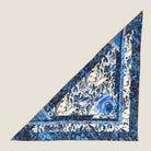 100% silk Marble Rose Triangle Scarf in blue by Laslett England. Pictured laid flat against a neutral background. 