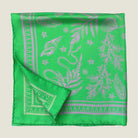 100% silk Marettimo Jewel Green Silk Bandana by Laslett England shown folded into four in flat lay against a neutral background. 