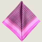 This Matrix Pink pocket square has a striking geometric design that reveals, on closer inspection, repeating graphic lines and patterns. In soft dusty pink with charcoal and white, square is shown folded into two triangles against a neutral background. 