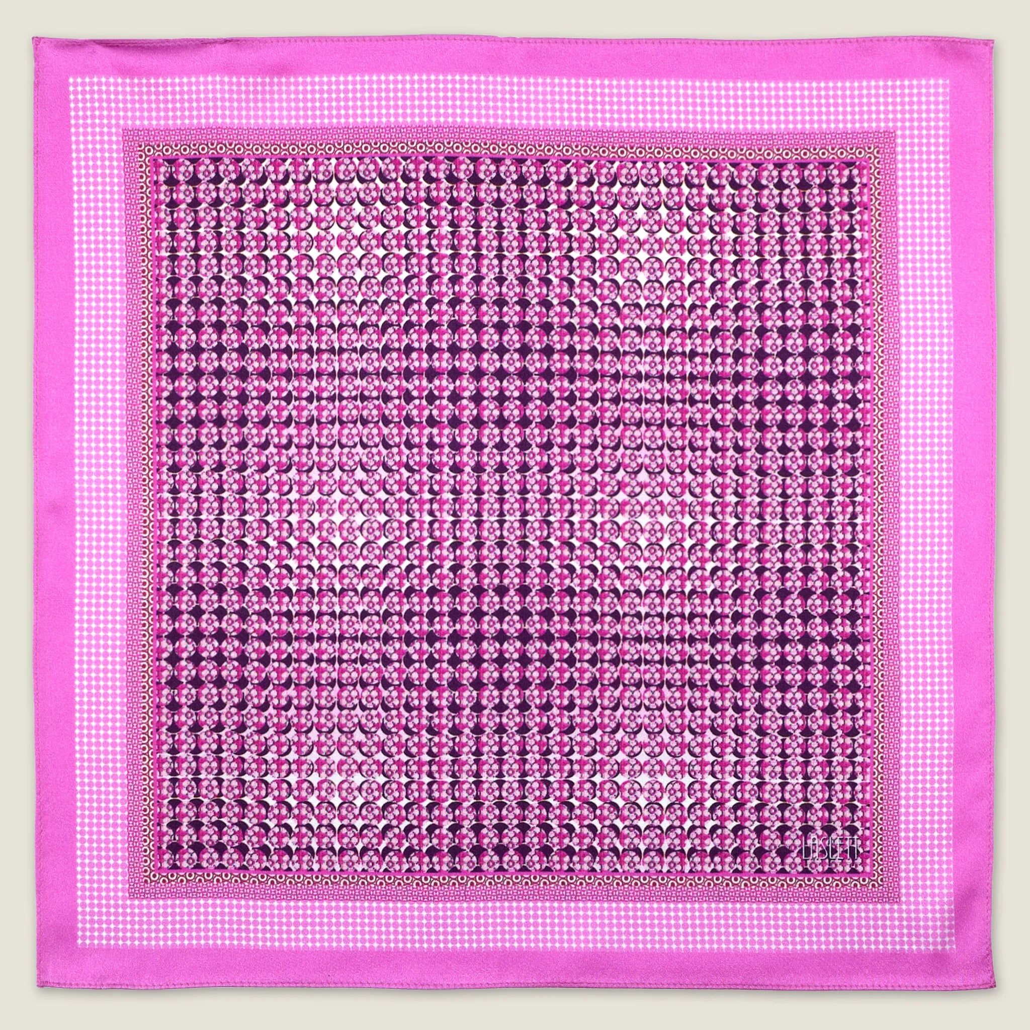 This Matrix Pink pocket square has a striking geometric design that reveals, on closer inspection, repeating graphic lines and patterns. In soft dusty pink with charcoal and white, square is shown in flat lay against a neutral background. 