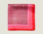 100% Matrix Red pocket square has a geometric design with a floral repeat that reveals itself on closer inspection. Square is shown folded into four on a neutral background. 