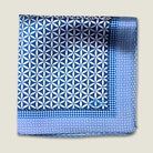 100% silk Moresque Blue pocket square from Laslett England shown folded into four against a neutral background to demonstrate the smaller geometric pattern of the border. 