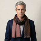 Laslett England Mosaic Copper Silk Oblong worn looped at neck by male model in navy jacket, showing warm copper and brown trellis print on silk twill.