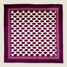 Oval Spot Burgundy pocket square in flat lay against a neutral background showing off the modern retro oval spot pattern. 