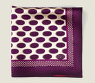 Oval Spot Burgundy pocket square shown folded into a quarter with the Laslett signature on display. 