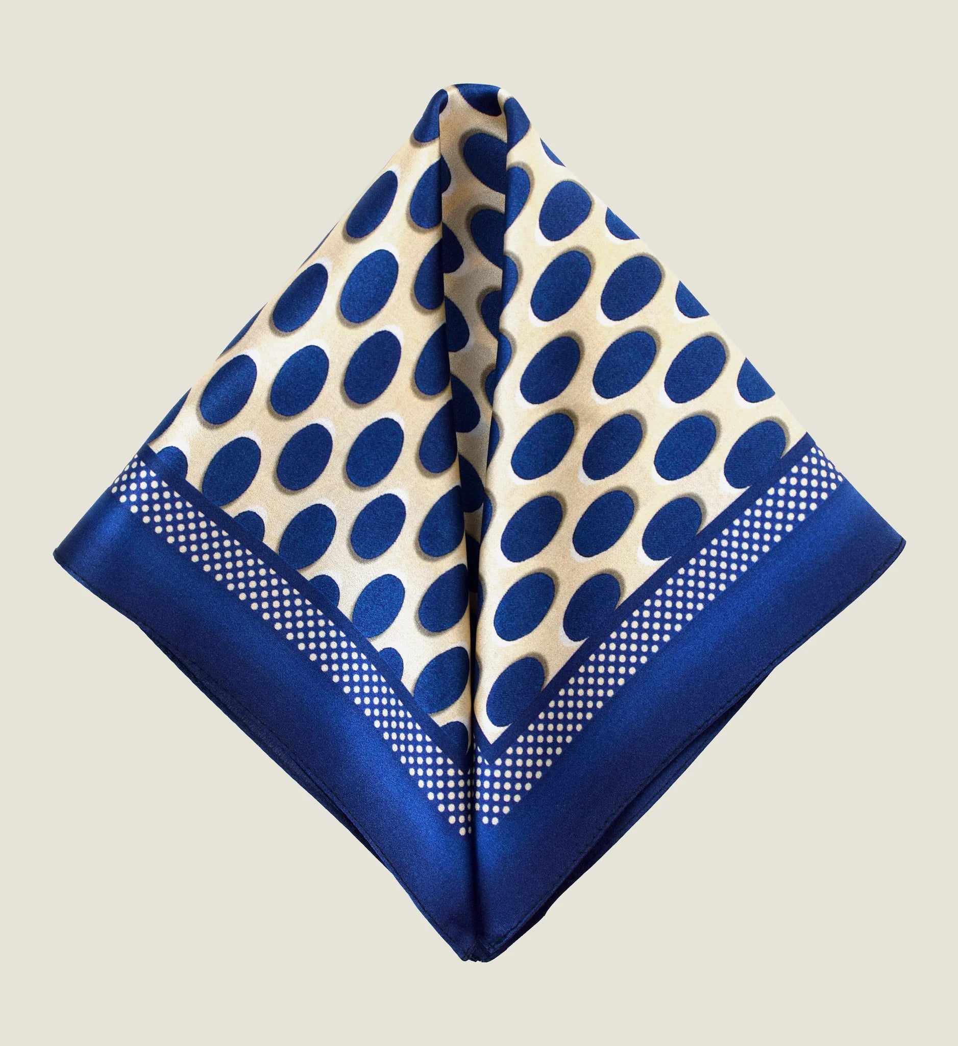 Laslett England Oval Spot Navy silk pocket square folded to diamond point, cream and navy oval spot print